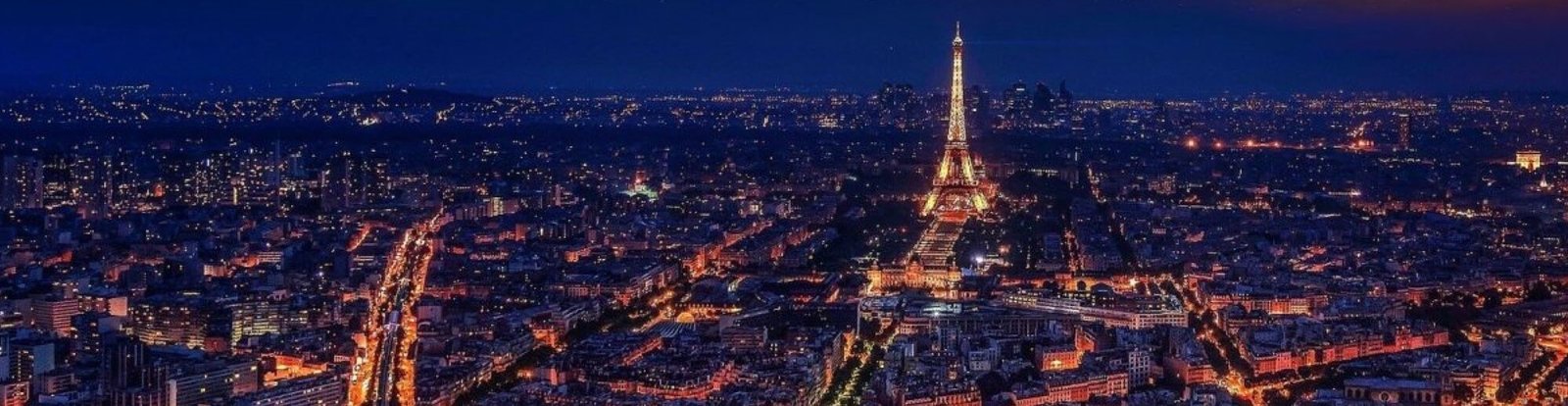 Tour Eiffel illuminée de nuit avec vue sur la ville de Paris et ses lumières