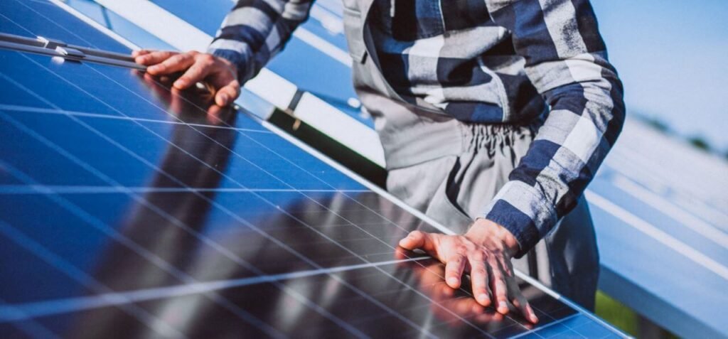 électricien photovoltaïque avec les mains posées sur un panneau